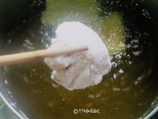 5、干炸五花肉,锅上火烧热倒入植物油烧至六成热，将肉片一片一片放入锅中炸至微黄色捞出来。