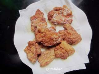 7、干炸五花肉,将刚才炸锅的肉片倒入锅中炸至2～3秒立刻捞出放在吸油纸上吸一下即可