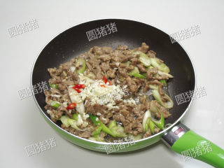 7、葱爆羊肉,继续大火爆炒约30秒,加入蒜碎及红椒片。