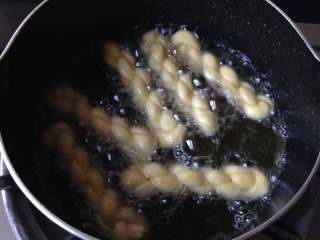 11、香脆小麻花,放入麻花生坯，并用筷子时常翻翻面，使其受热均匀，炸至金黄捞出即可