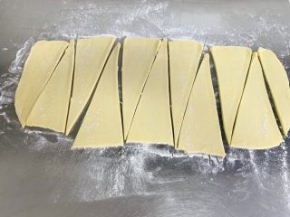 12、牛角酥,快速地用尺子称量切成三角形。