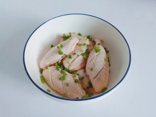 3、蒜香鸡翅,鸡翅放入大碗里面，撒点香葱提香。加上蒜泥【此处蒜泥可以一点多】