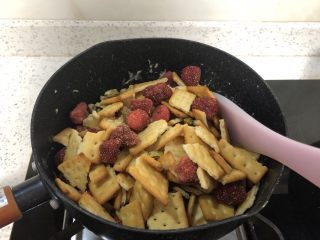 9、网红～～～抹茶雪花酥,倒入饼干+草莓干+开心果混合物，搅拌。