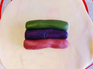 10、彩虹蛋黄酥,一份水油皮，用手掌压扁之后，用擀面杖擀开，把三色的油酥放上去