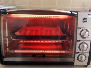 9、黑椒烤肠,把烤盘放入预热好的烤箱里，上下火200W，烤5分钟