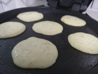 6、香蕉软饼,用小勺子盛一勺子放入电饼铛中
