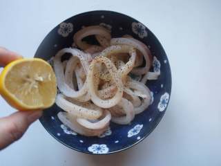 3、香酥鱿鱼圈,加入适量食盐，磨少许黑胡椒，挤几滴柠檬汁