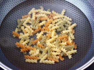 2、火腿肠时蔬炒意面便当,锅中倒入适量的清水，把意面放入锅中，大火烧开后，煮熟捞出沥干水分备用。