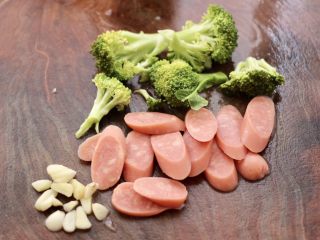 4、火腿肠时蔬炒意面便当,火腿肠切片，大蒜去皮后切片，西兰花用手撕成小朵。