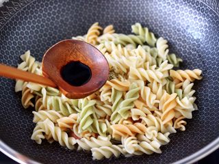 9、火腿肠时蔬炒意面便当,再倒入生抽调味调色。