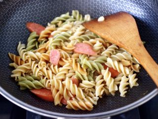 10、火腿肠时蔬炒意面便当,大火继续快速翻炒片刻。