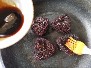 6、紫米饭团,不粘平底锅刷一层薄油，烧热后放入饭团，一面煎挺实后在上面刷一层调好的料汁。