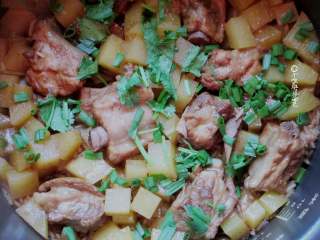 7、排骨焖饭,煮饭结束后把米饭拌匀，撒上少许香菜和葱花再焖5分钟