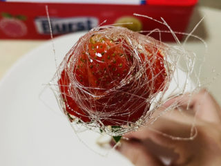 8、拨丝冰糖草莓,匀上糖浆后需用筷子沾上糖浆，拔出糖丝裹到草莓上。