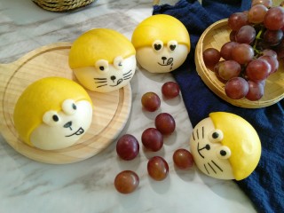 12、换装机器猫小馒头,最后，黄色面团包裹着白面团，贴上眼睛。蒸熟后，用可食用色素笔，画上你喜欢的表情吧！这是蒸好的样子！