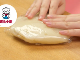 2、网红Q香橘子大福,案板铺张保鲜膜，蒸好的面团趁热倒出，摊平，用保鲜膜包好，静置放凉