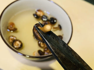 7、香菇腊肠焖饭,把根剪掉；