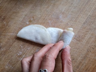 9、玫瑰花蒸饺,再将饺子皮从一边卷起。