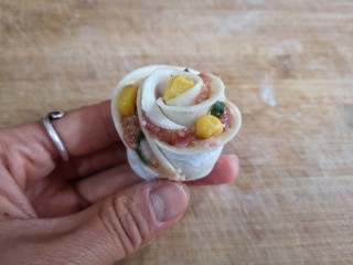 11、玫瑰花蒸饺,将卷好的饺子皮调整一下,玫瑰花就成型了。