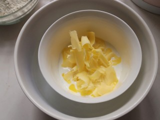 2、网红便当盒子蛋糕,牛奶隔热水加热,倒入黄油,用牛奶的温度融化黄油