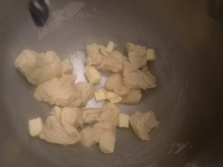 8、超软豆沙面包圈—家庭手作小点心,把面团切成小份。加入软化好的15克无盐黄油。