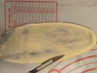 20、超软豆沙面包圈—家庭手作小点心,擀成牛舌状的面团。拿一把锋利的小刀。