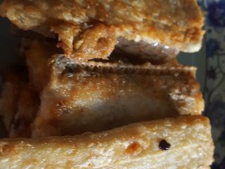 6、红烧带鱼,6.全部带鱼段炸好后盛在盘中备用。