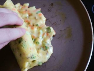 11、宝宝辅食之时蔬厚蛋烧,待凝固半熟状态用手卷起,注意是卷起一部分