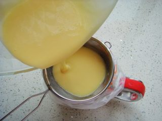 8、蔓越莓鲷鱼烧,杯子套上裱花袋，把糊糊过筛倒入裱花袋里。（糊糊更细腻）