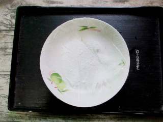 11、椰蓉南瓜小方,取一只干净盘子，贴上保鲜膜，方便脱模，均匀的撒上一些椰蓉，方便到时候脱模。