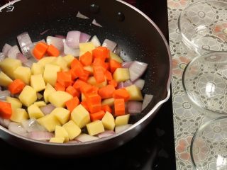 11、土豆咖喱鸡,加入土豆、胡萝卜，大火翻炒两分钟左右。