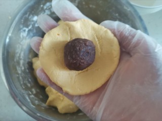 7、南瓜豆沙饼,揪一块面团压成饼状，包入豆沙