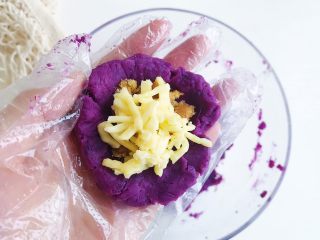 4、紫薯芝士风味球,取适量紫薯泥 捏成小碗状 依次加入搅拌好的肉松和芝士