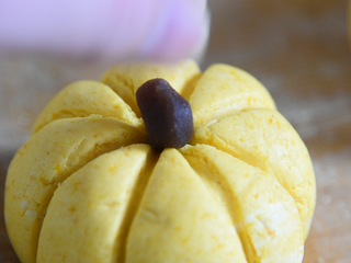 10、只需一根牙签,新手也能做出以假乱真的漂亮,黄金南瓜包,再去少许豆沙放在南瓜顶上,南瓜造型就完成了