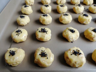 11、花生酥饼,稍微压扁一下,表面刷上蛋液,沾上黑芝麻