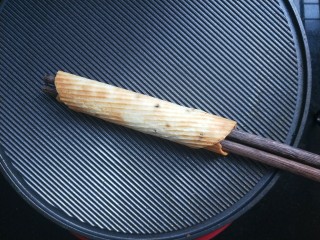 8、香酥芝麻蛋卷,卷好压一下边。然后抽出筷子。可以两只手分别握住筷子的两端来卷。卷的过程一定要快。一打开锅盖就卷。不然卷不起来了。注意不要烫手。