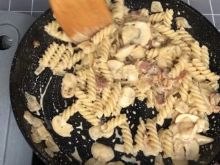 13、奶油蘑菇培根螺旋意面,汤汁收到一半后捞出百里香，煮好的意面沥水倒入锅中一起翻拌均匀