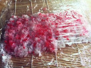 8、樱花寿司,再盖上一张保鲜膜，提起下面的保鲜膜翻转过来。