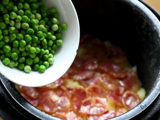 6、香肠土豆焖饭,10.电锅跳了以后，揭开盖，将速冻豌豆倒入锅中。