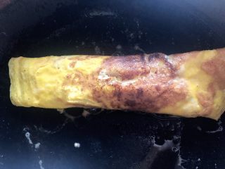 3、爆浆鸡蛋卷,芝士软了后，将鸡蛋卷起来（我家锅不行，有一点点糊）。