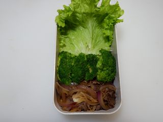 9、卡通招财猫牛肉饭便当盒,在铺上一片生菜。