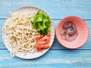 2、黑椒虾仁炒乌冬面,青椒火腿切块。虾仁去壳去虾线,加一小勺料酒,生抽,淀粉搅拌均匀腌制5分钟。