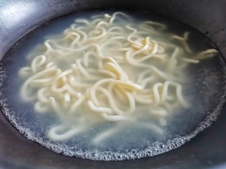 3、黑椒虾仁炒乌冬面,锅中烧开水,乌冬面放入锅中煮2分钟。