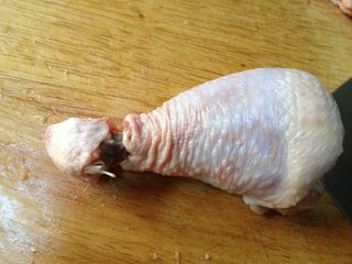 2、照烧鸡腿饭,鸡腿洗净后开始脱骨,先在鸡腿根部用刀划一圈,将鸡的皮、肉、筋与骨头分离