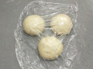 4、牛奶吐司,平均分成三份。滚圆，盖上保鲜膜松弛十分钟。