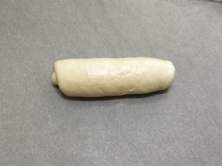 6、牛奶吐司,从一头卷起成条，再次盖上保鲜膜松弛十分钟。