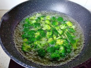 7、干锅西兰花,另起锅加水烧开，放入西兰花焯水，加一点点盐。想要做好的西兰花颜色碧绿，可以加一点点的小苏打，焯水一分钟捞出控水。