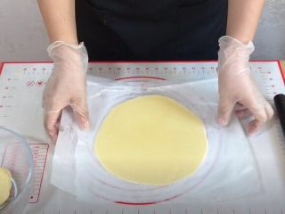 4、外酥里嫩的~爆浆芝士塔,隔油纸，用擀面杖擀成比模具大一圈的薄饼。