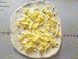 9、 海苔芝士玛德琳咸面包,将小面团擀成圆形放入软化好的马苏里拉芝士碎