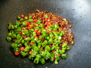 5、#猪年#辣子肉,肉末炒匀上色之后,会变得比较干一些,这个时候就可以把辣椒放进去